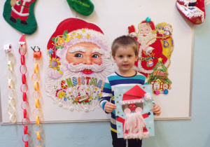 Chłopiec prezentujący prace konkursową "Mikołaj"